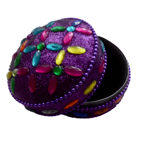 Glittrig nipperask, en liten rund plåtask i lila färg. med färgglad dekoration. Insidan och botten fodrade i svart. Bild med öppen ask.
