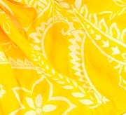 Tunn, mjuk sjal i bomull i klar gul färg med vitt, slingrande blomstermönster, här i detaljbild. 180x50cm. Fair Trade från Indien.