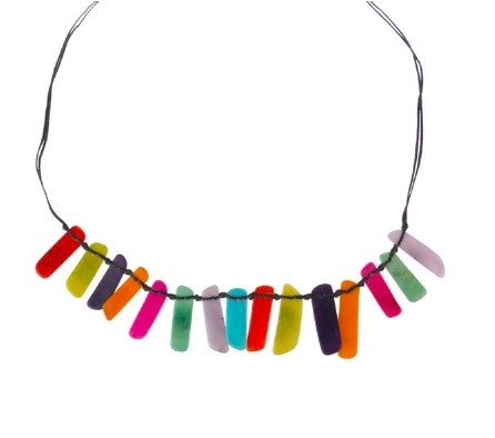 Halssmycke Slices, multicolor, taguanöt, 15 tunna avrundade bitar i olika färger.  Justerbart halsband av bomullsnöre. Fair Trade. Detaljbild på taguabiterna.