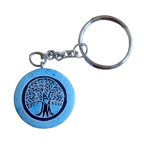 Nyckelring, en platt, rund täljsten i ljusblå. Med inristat motiv Livets träd. Handarbete från Kenya för Fair Trade.