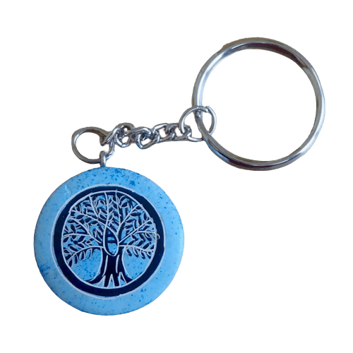 Nyckelring, en platt, rund täljsten i ljusblå. Med inristat motiv Livets träd. Handarbete från Kenya för Fair Trade.