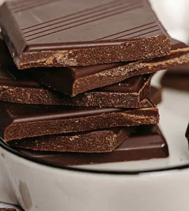 Choklad Choco4change Vegan. Bild med chokaldbitar som innehåller läckert dadelmos och hasselnötspasta.