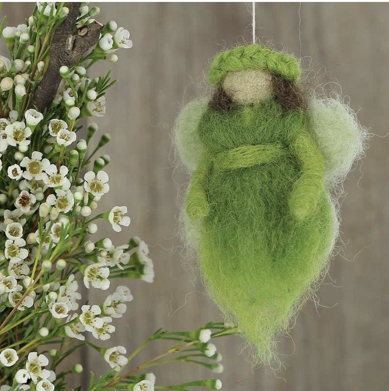 liten glad och god fe eller ängel eller kanske älva eller skyddsängel i grön färg. Bild med deko.