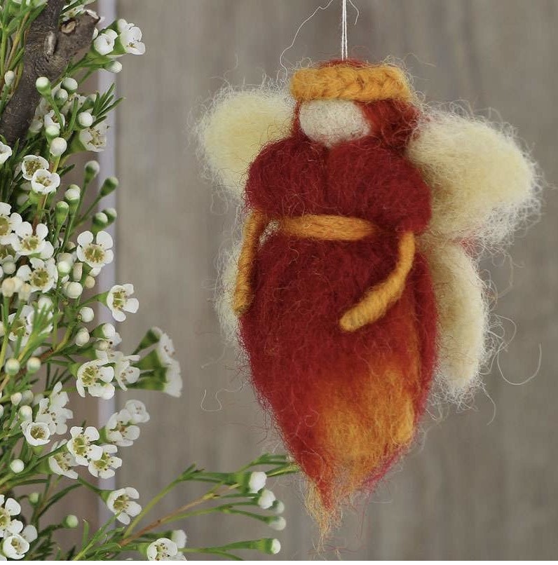 En liten glad och god fe eller ängel eller kanske älva eller skyddsängel i höstens färger. fin deko för höststämning. Tovad, Fair Trade Nepal. Bild med deko.