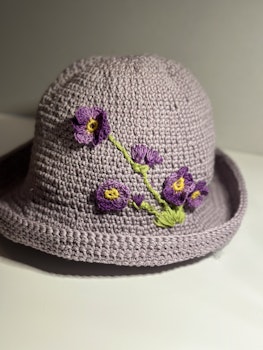 Hatt med lila blommor