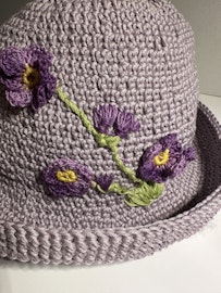 Hatt med lila blommor