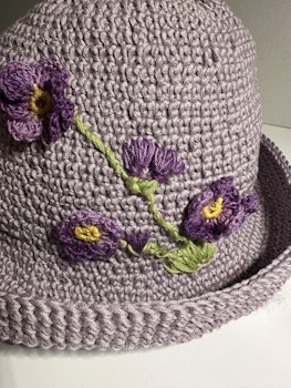 Hatt med lila blommor