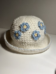 Vit hatt med blå blommor med blå kant
