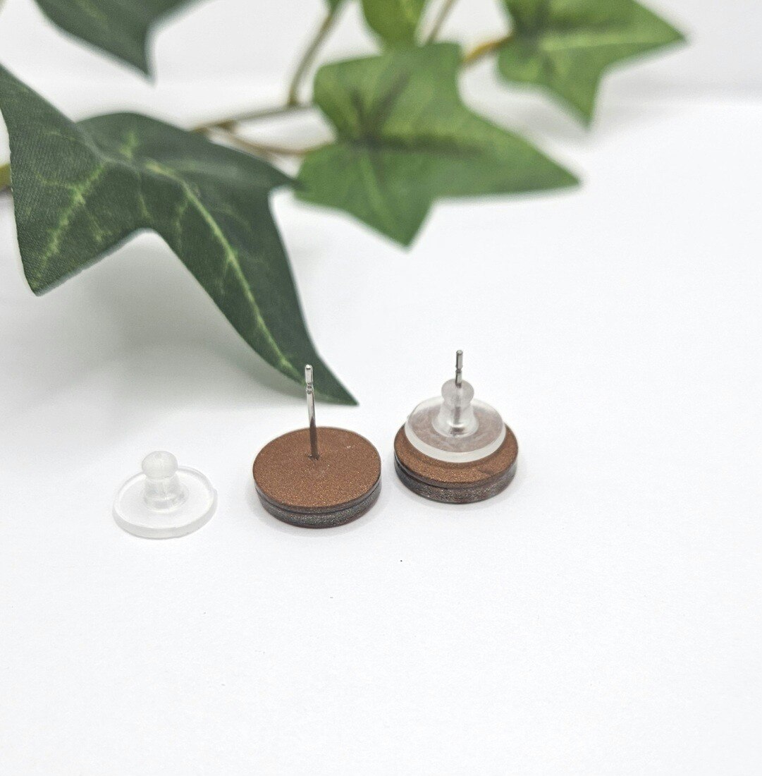 Glänsande studs i svart och koppar