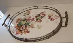 Oval bricka i metall med floral dekor på porslin