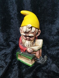 Spargris tomte som sitter på en bok retro