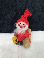 Liten trä tomte som har en säck och lykta