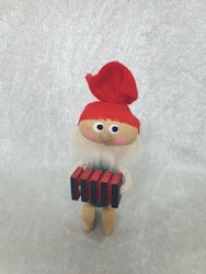 Äldre tomte som spelar dragspel i trä