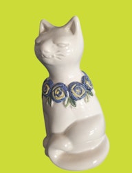Rosa Ljung katt med blå blomsterkrans runt halsen