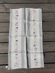 Vävd duk grå/beige duk med broderade blommor.