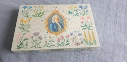 Låda med motiv av Carl Von Linne, full med broderigarn