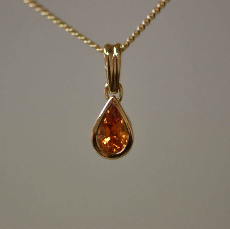 Guldhänge med orange safir