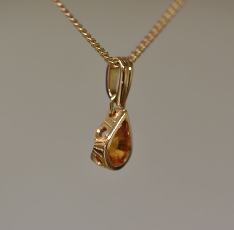 Guldhänge med orange safir
