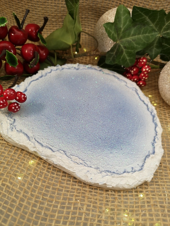 platta till julfigurer i halvcirkelsform med blå och vit botten.