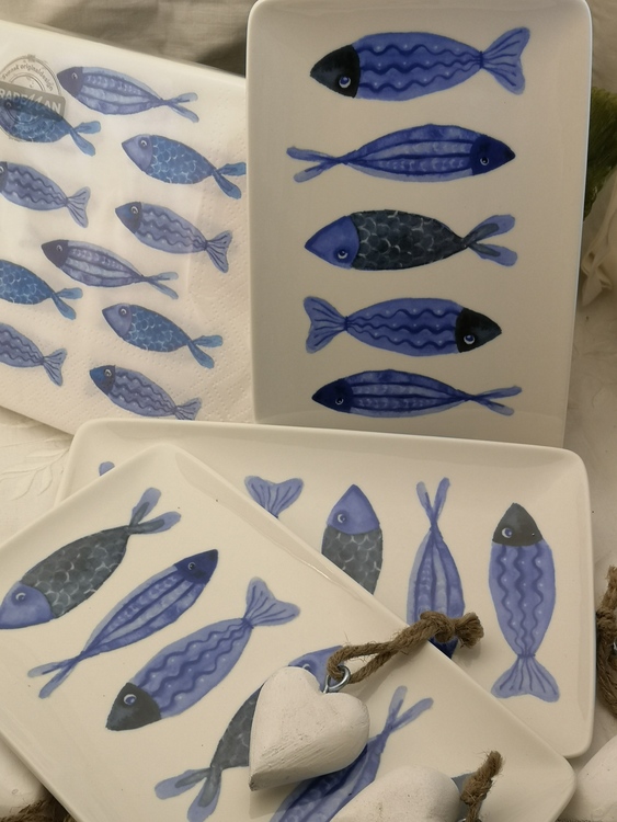 Assietter med blåa fiskar som motiv. Varannan har huvudet uppåt respektive nedåt.