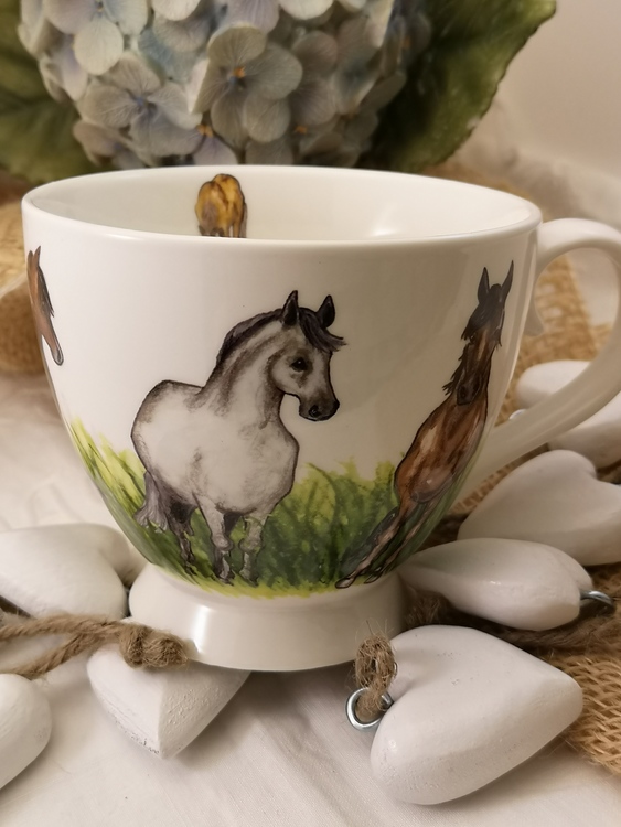 Tekopp med hästar och gräsfält. På denna bild en vit häst och en brun häst bredvid som tittar framåt. Dessutom häst på insidan av koppen.