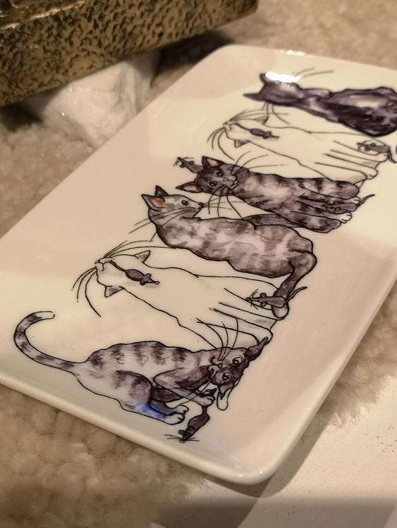 Katter och små möss på assiett i porslin.