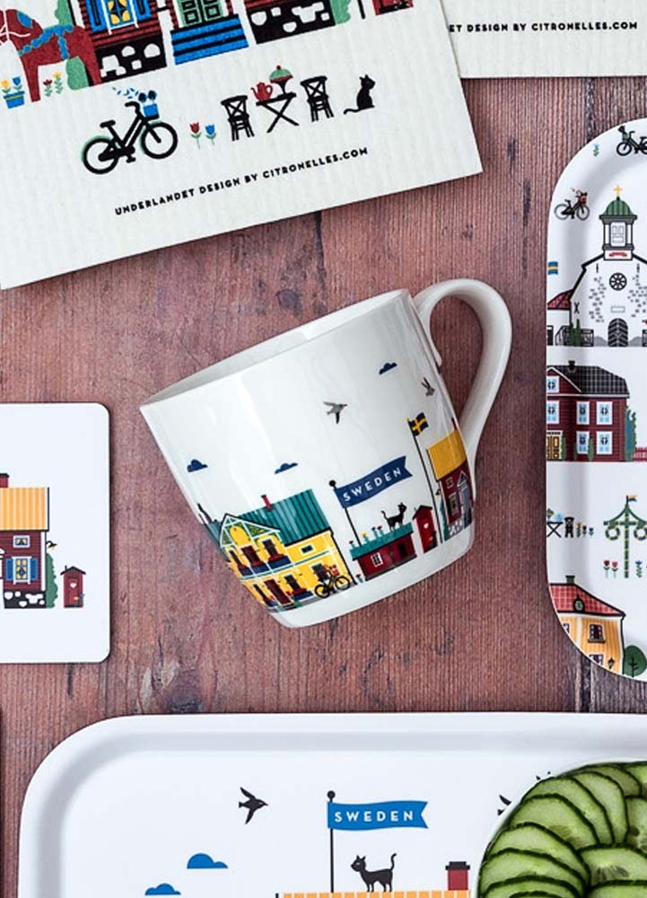 Vit mugg i benporslin med klassiska svenska hus