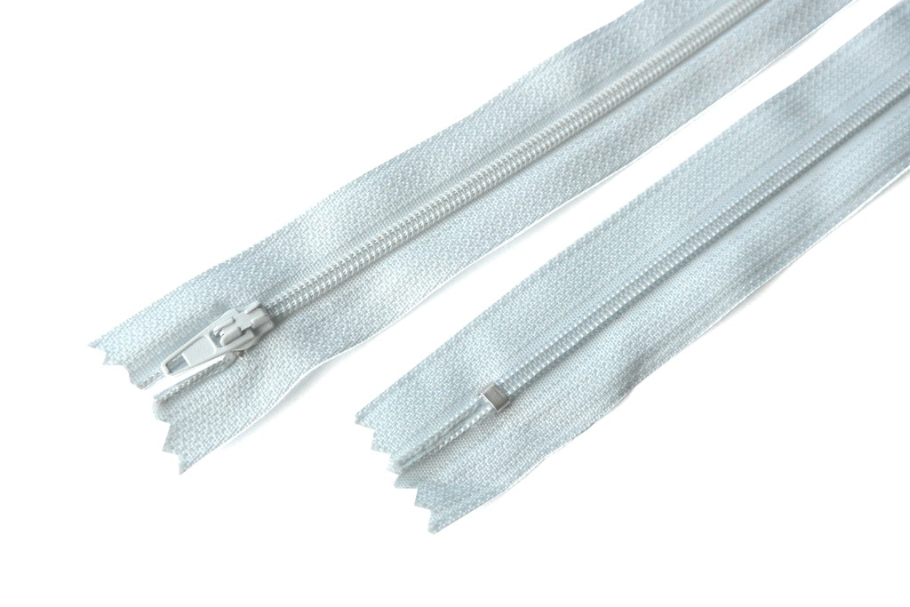 18 cm dragkedja. Ljus blågrå.