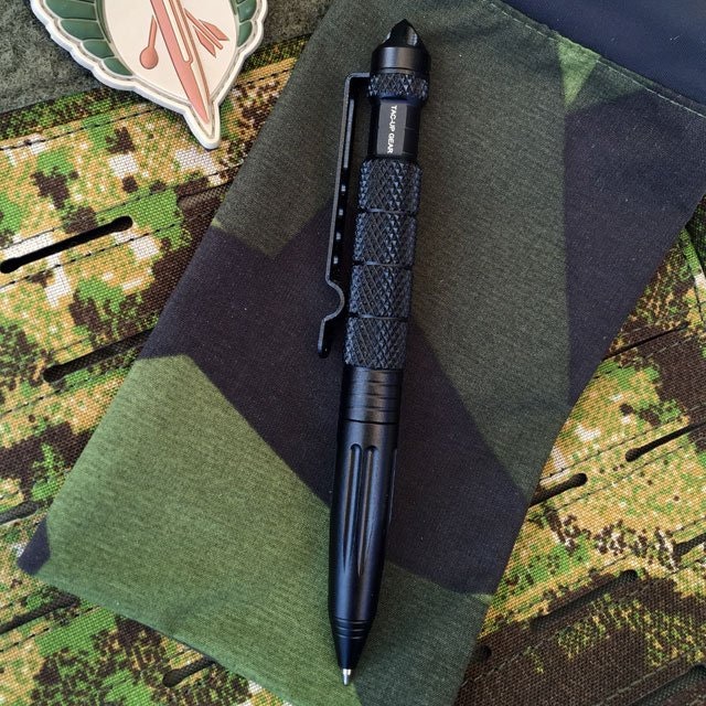 A Pen Tactical Black on M90 camouflage background.