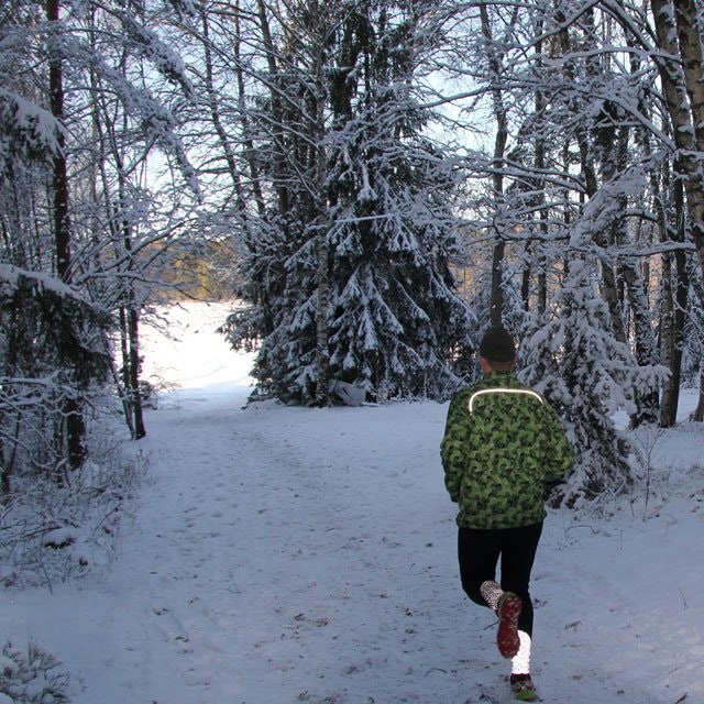 Reflective shoulder stripe showing on runner in Swedish winter scenery wearing a Running Jacket M90 MI.