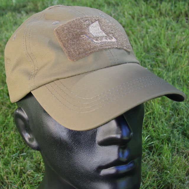 Baseball Cap Coyote with green grass background.
