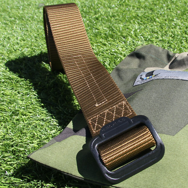 Grassy background and the sun is out, featuring a Expedition Belt Coyote on a M90 bag.