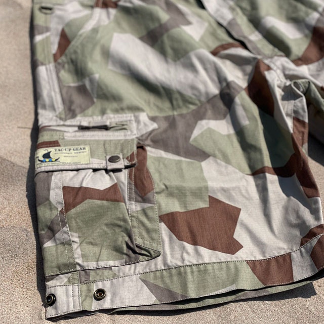 A pair of Camp Shorts M90K Desert from TAC-UP GEAR  lying flat on the sand