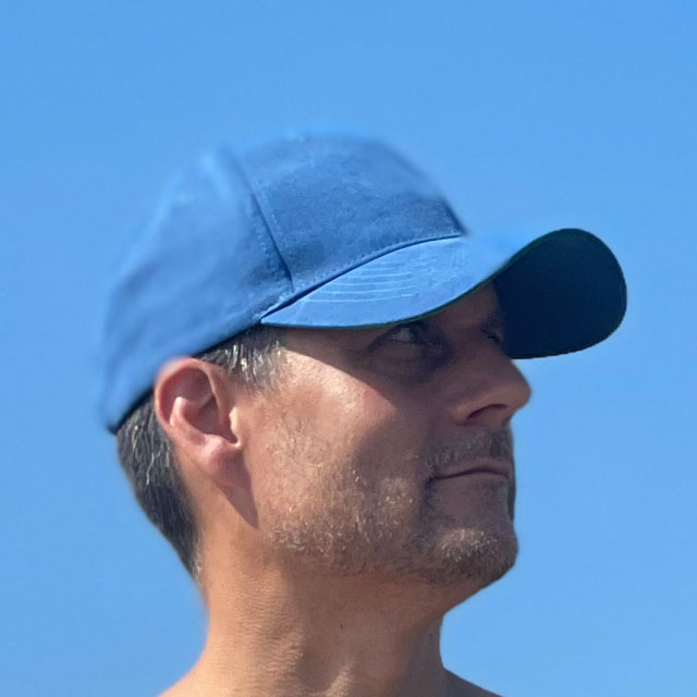 Baseball Cap Blue on the beach seen from the right and worn by model