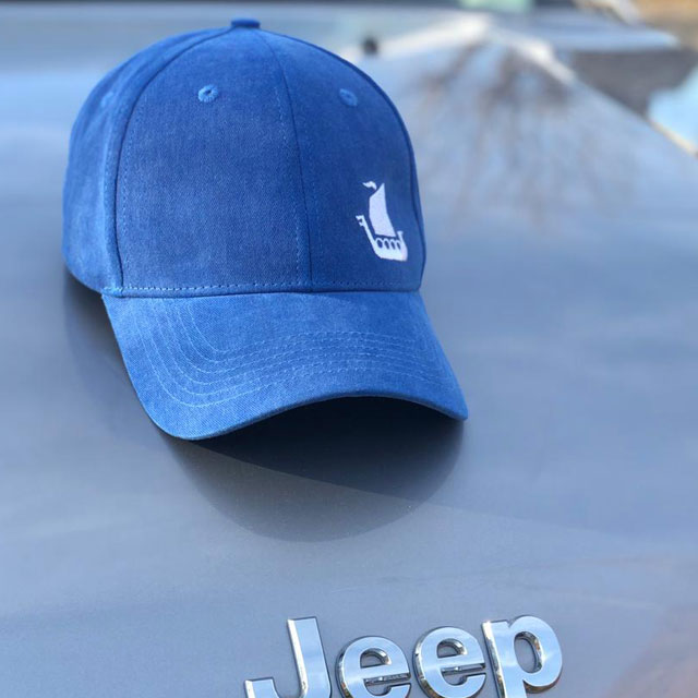 Baseball Cap Blue on the hood of a Jeep car