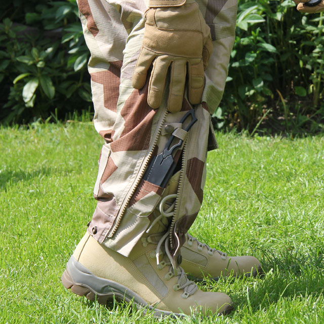 Grabbing a knife from the hidden knife pocket on a pair of Field Trousers M90K Desert and also showing green summer grass..