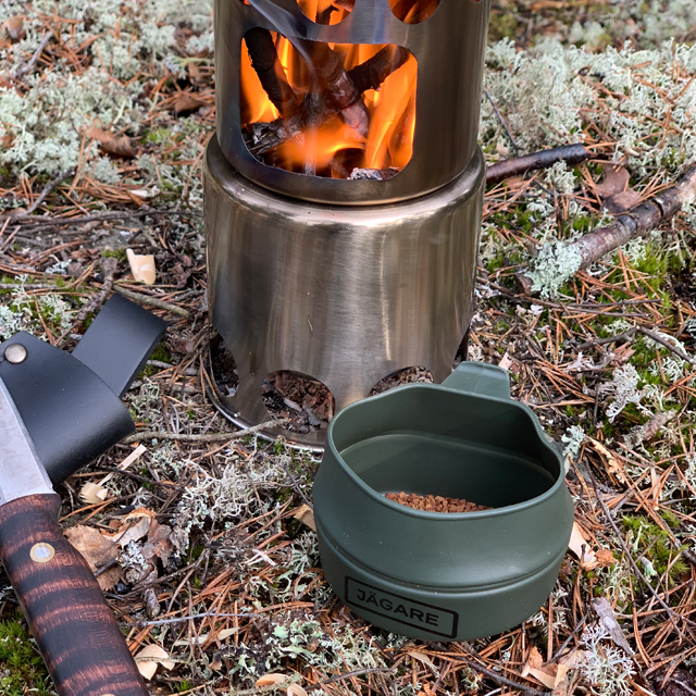 Folding Cup JÄGARE OD Black/Green/Black on the ground in Swedish forest with instant coffee in it