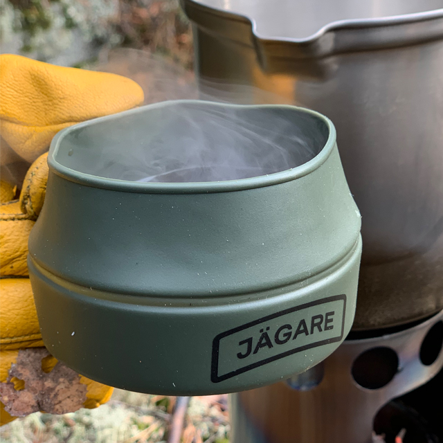 Close up on a Hot smoking coffee in a Folding Cup JÄGARE OD Black/Green/Black in the Swedish forest