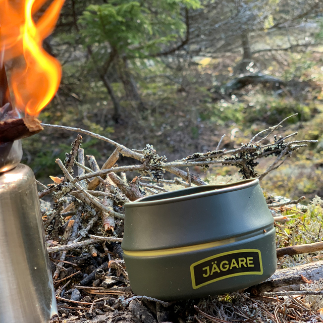 Lit stove and a Folding Cup JÄGARE OD Yellow/Black/Yellow in the Swedish forest