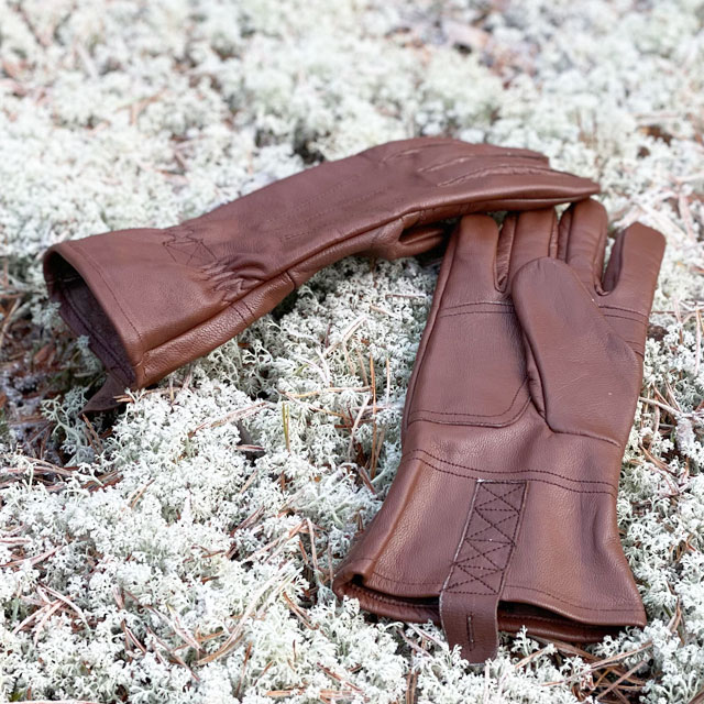 A pair of Bushcraft Leather Glove Brown from TAC-UP GEAR on white moss in the Swedish forest