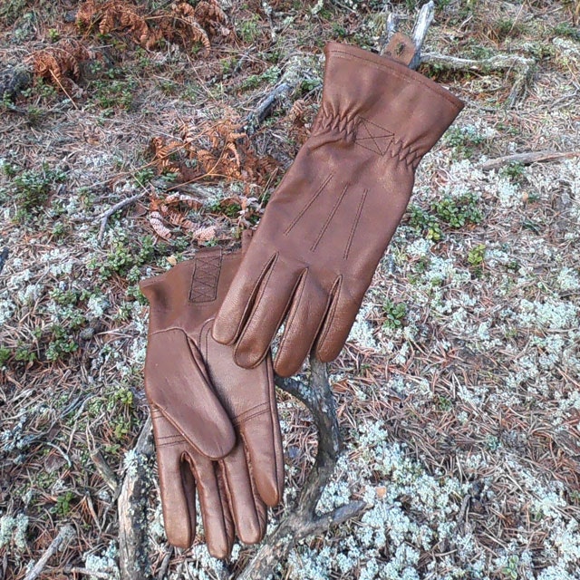 A pair of Bushcraft Leather Glove Brown from TAC-UP GEAR in the Swedish forest