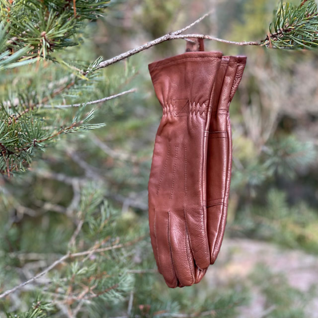 Bushcraft Leather Glove Brown from TAC-UP GEAR hanging on a branch