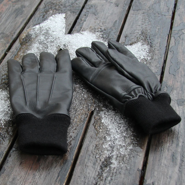 Snow and ice and two Officer Black Leather Gloves.