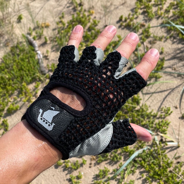 Seen from the top a Training Glove Net Black with beach sand and green background