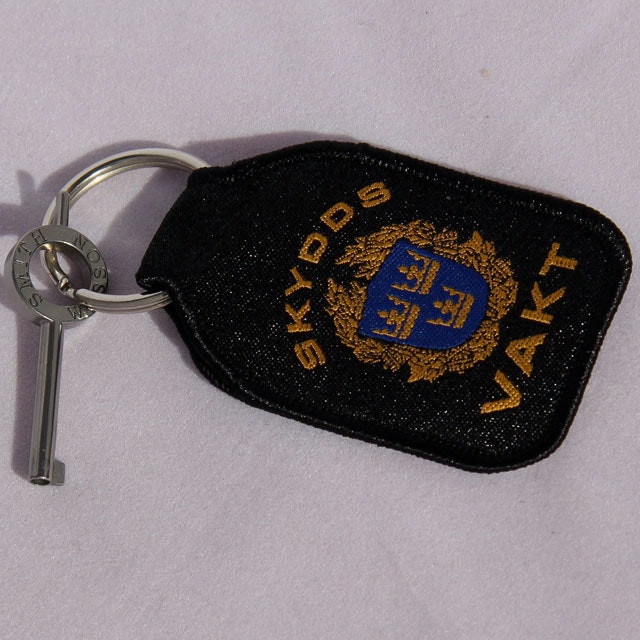 Nyckel till handfängsel monterad på silverringen på en Skyddsvakt Nyckelring.