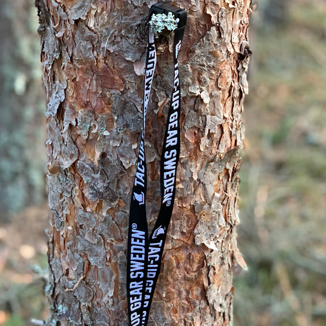 Lanyard Black/White hanging on a tree in the forest