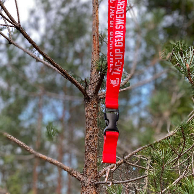 Lanyard Red/White in focus hanging on a branch in the forest