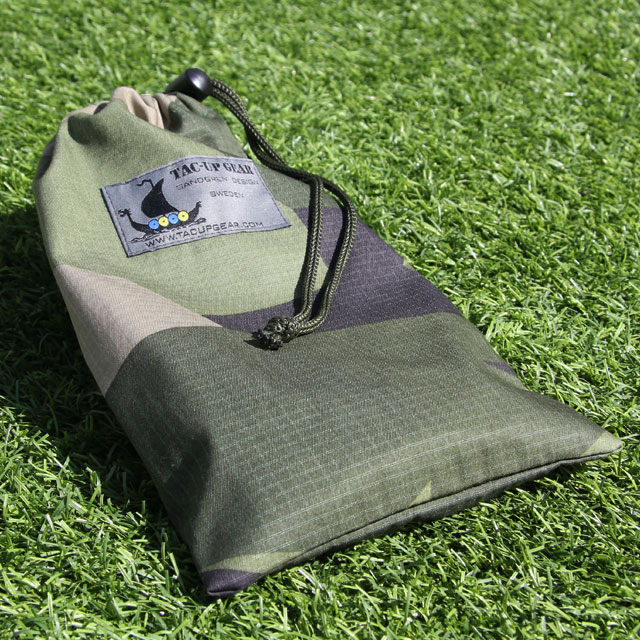 Mini Bag Ripstop M90 in the sun laying on grassy ground showing the ripstop fabric and camouflage.