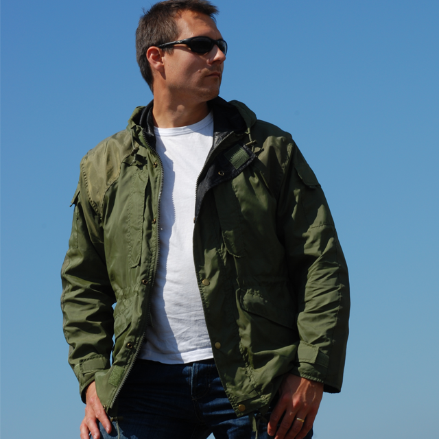 Casual open and worn Nomad Jacket Green in bright blue sky scenery.