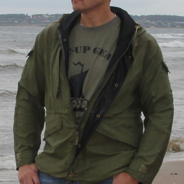 Casual open and worn Nomad Jacket Green at autumn beach scenery.